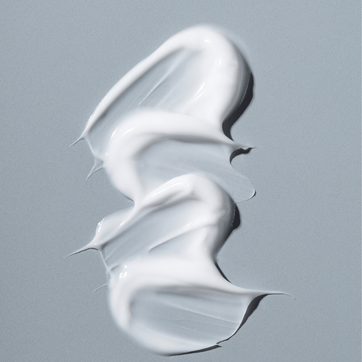 Augencreme gegen Trockenheitsfältchen auf grauem Hintergrund, pasteuse Textur für strahlende Augen.